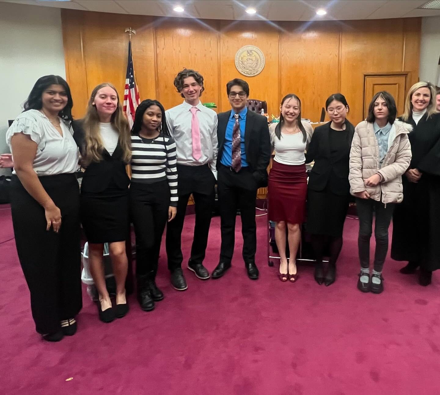 The Mock Trial team standing together in a courtroom