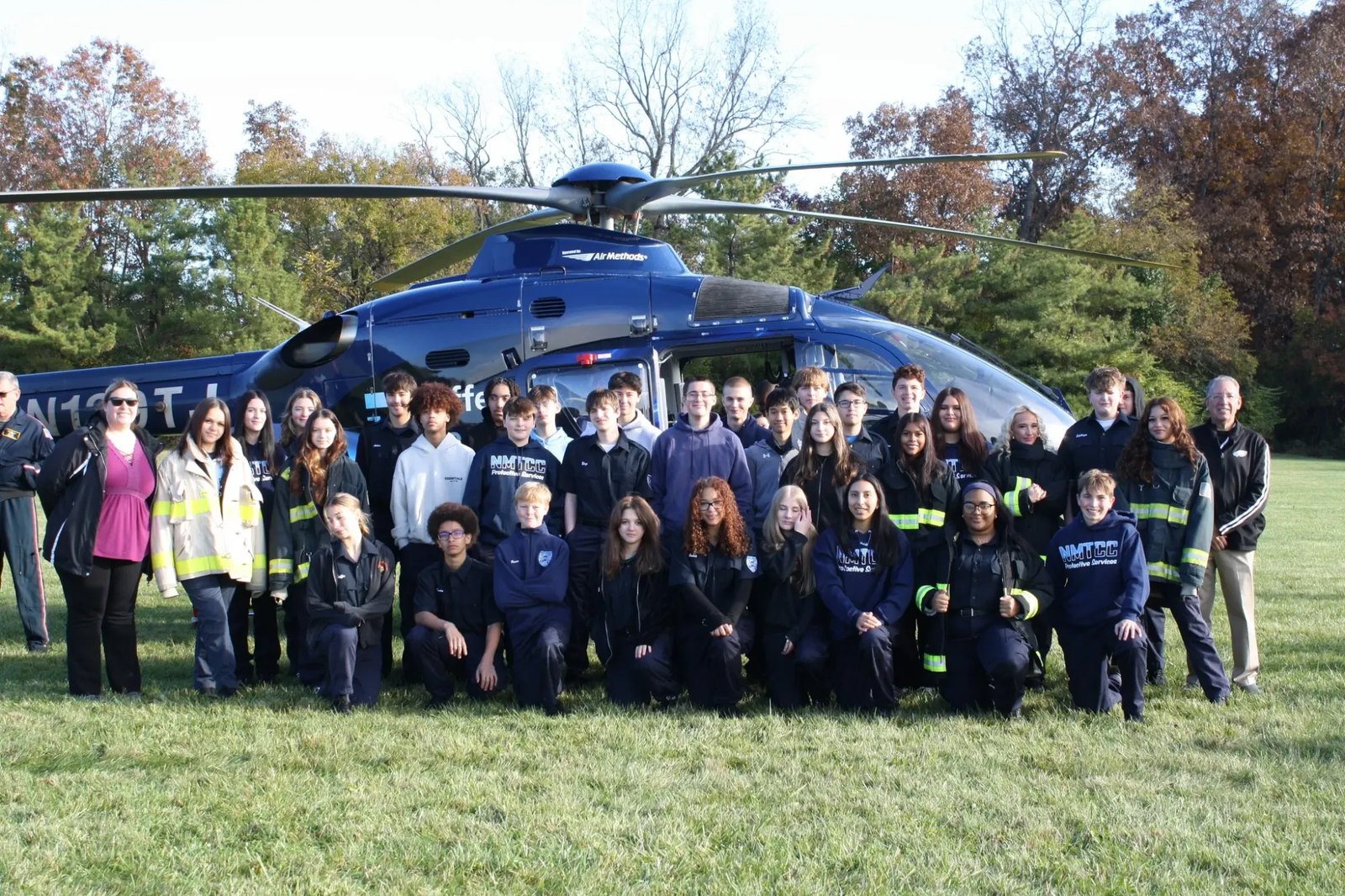 North Montco Technical Career Center Protective Services students in front of a medical helicopter on a field
